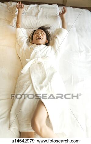 Woman jumps backwards onto a bed View Large Photo Image Stock Photo - Woman jumps backwards onto a bed. Fotosearch