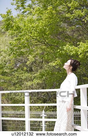 Woman leaning against a railing View Large Photo Image Stock Image - Woman leaning against a railing. Fotosearch