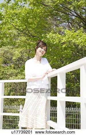Woman leaning against a railing View Large Photo Image Stock Image - Woman leaning against a railing. Fotosearch