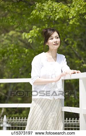 Stock Photo - Woman leaning against a railing. Fotosearch