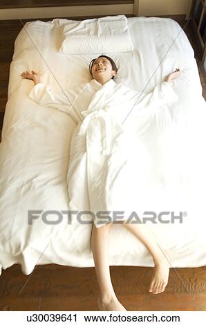 Woman lying on a bed View Large Photo Image Stock Image - Woman lying on a bed. Fotosearch