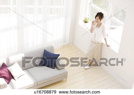 Woman on the phone in living room View Large Photo Image Stock Photo - Woman on the phone in living room. Fotosearch