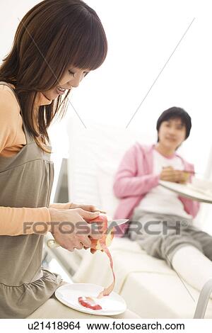 Picture - Woman peeling an apple for her boyfriend. Fotosearch