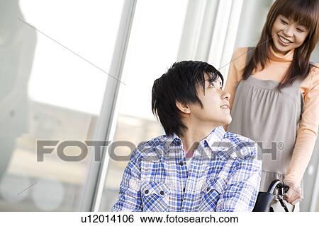 Woman pushing her boyfriend in a wheelchair View Large Photo Image Stock Photograph - Woman pushing her boyfriend in a wheelchair. Fotosearch