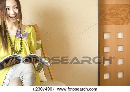 Stock Photo - Woman reading a magazine. Fotosearch