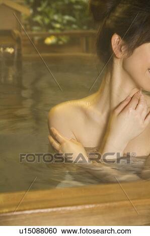Stock Image - Woman relaxing in a hot tub. Fotosearch