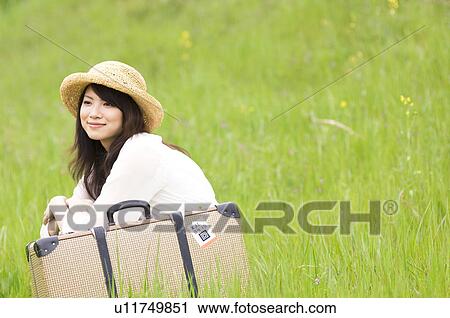 Woman sitting in field with suitcase View Large Photo Image Stock Image - Woman sitting in field with suitcase. Fotosearch