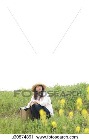 Woman sitting in field with suitcase View Large Photo Image Stock Image - Woman sitting in field with suitcase. Fotosearch