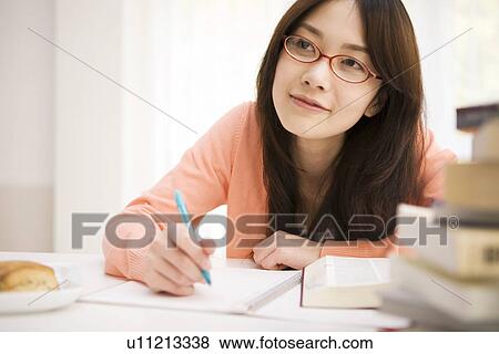 Woman studying at her desk View Large Photo Image Stock Photo - Woman studying at her desk. Fotosearch