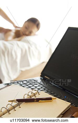 Picture - Woman takes a break from her work to get a massage. Fotosearch