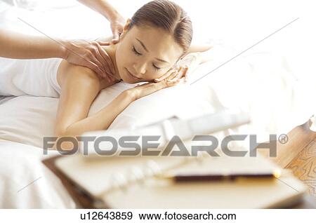 Woman takes a break from her work to get a massage View Large Photo Image Stock Photo - Woman takes a break from her work to get a massage. Fotosearch
