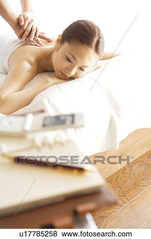 Woman takes a break from her work to get a massage View Large Photo Image Stock Photo - Woman takes a break from her work to get a massage. Fotosearch