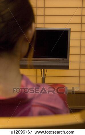 Stock Photo - Woman wearing yukata looking at blank TV screen. Fotosearch