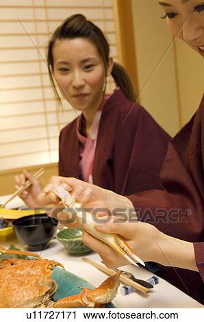 Stock Image - Women in yukatas eating seafood. Fotosearch