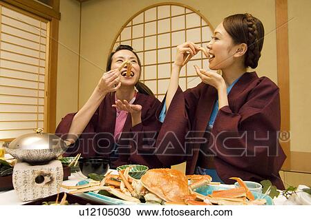 Stock Image - Women in yukatas eating seafood. Fotosearch