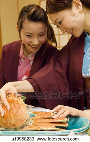 Stock Image - Women in yukatas eating seafood. Fotosearch
