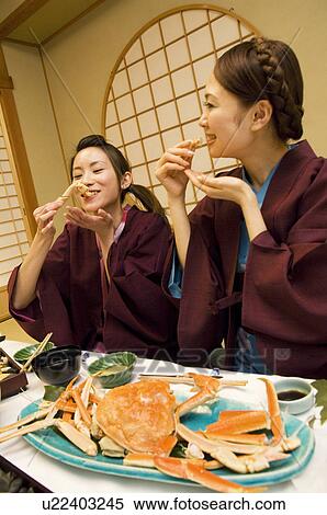 Stock Photography - Women in yukatas eating seafood. Fotosearch