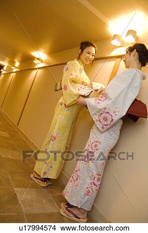 Women wearing yukata standing talking in hallway of health spa View Large Photo Image Picture - Women wearing yukata standing talking in hallway of health spa. Fotosearch