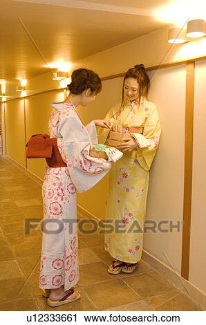 Women wearing yukata standing talking in hallway of health spa View Large Photo Image Stock Image - Women wearing yukata standing talking in hallway of health spa. Fotosearch