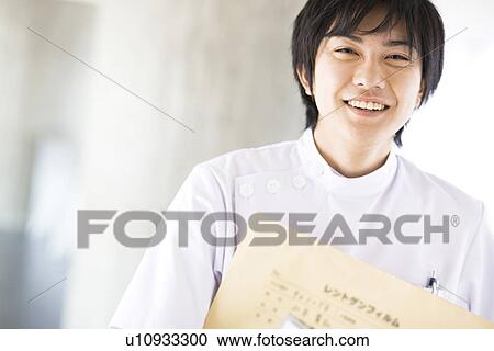 Stock Image - X-ray technician smiling at the camera. Fotosearch