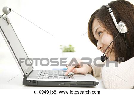 Young woman at computer using webcam View Large Photo Image Stock Photo - Young woman at computer using webcam. Fotosearch