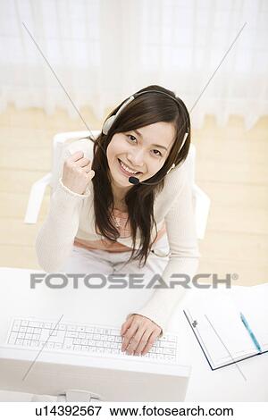 Stock Photo - Young woman at computer working from home. Fotosearch