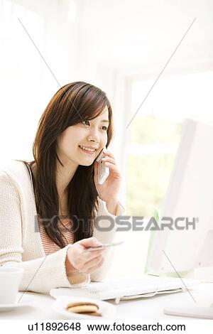 Young woman on the phone holding credit card View Large Photo Image Stock Photo - Young woman on the phone holding credit card. Fotosearch