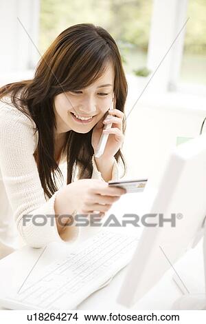 Picture - Young woman shopping online. Fotosearch