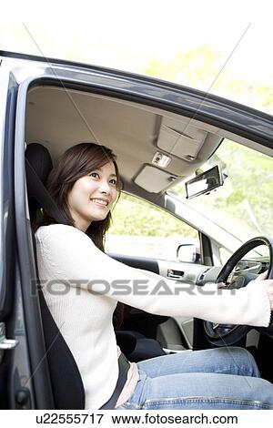 Young woman sitting in car View Large Photo Image Stock Photo - Young woman sitting in car. Fotosearch