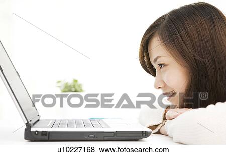 Young woman using laptop computer View Large Photo Image Stock Photo - Young woman using laptop computer. Fotosearch