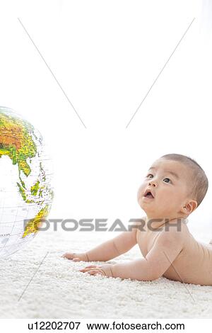 Stock Photo - Baby and an inflatable globe. Fotosearch
