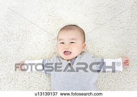 Stock Photo - Baby boy lying on rug. Fotosearch