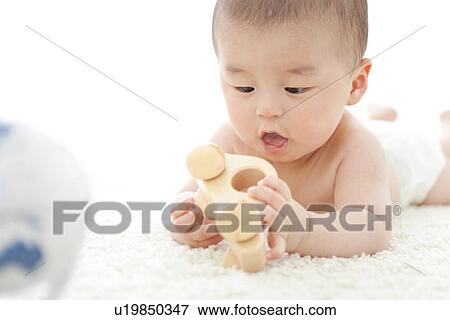 Baby boy playing with a toy car View Large Photo Image Stock Photo - Baby boy playing with a toy car. Fotosearch