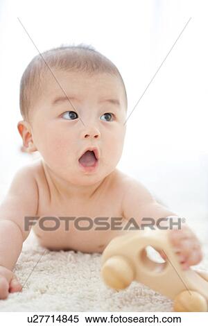 Baby boy playing with a toy car View Large Photo Image Stock Photography - Baby boy playing with a toy car. Fotosearch