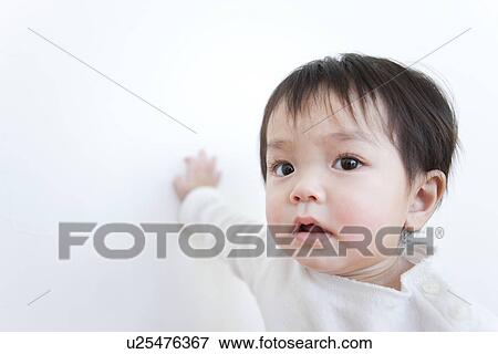 Stock Photo - Baby boy touching wall. Fotosearch