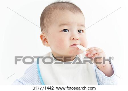 Stock Image - Baby eating with a spoon. Fotosearch