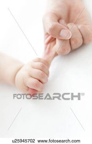Stock Image - Baby holding adult's finger. Fotosearch