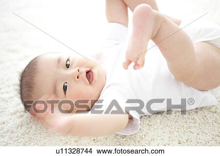 Baby lying on rug View Large Photo Image Picture - Baby lying on rug. Fotosearch