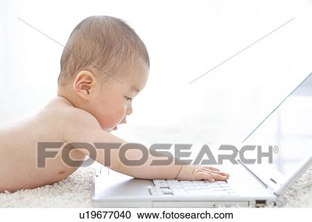 Baby playing with a laptop View Large Photo Image Stock Image - Baby playing with a laptop. Fotosearch
