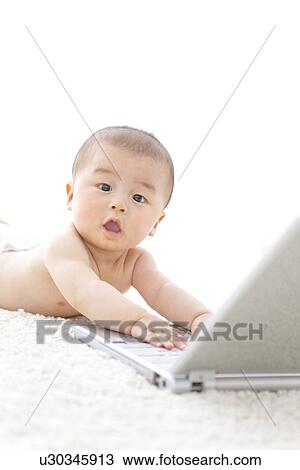 Baby playing with a laptop View Large Photo Image Stock Image - Baby playing with a laptop. Fotosearch