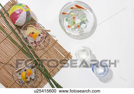 Stock Image - Bamboo, beach ball, fish bowl and cold fruit snacks and a tatami mat. Fotosearch