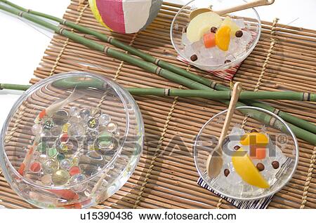 Stock Photograph - Bamboo, beach ball, fish bowl and cold fruit snacks on a tatami mat. Fotosearch