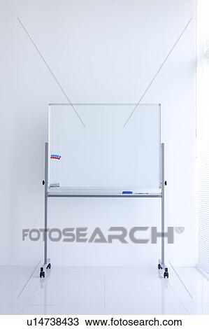 Stock Image - Blank whiteboard in empty office room. Fotosearch