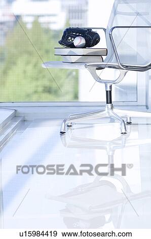 Stock Photo - Books, baseball glove and ball on a chair. Fotosearch