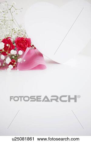 Stock Image - Bouquet of carnations and baby's breath with a heart shaped gift box. Fotosearch