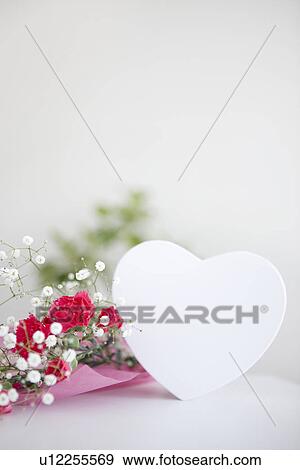 Stock Photo - Bouquet of carnations and baby's breath with a heart shaped gift box. Fotosearch