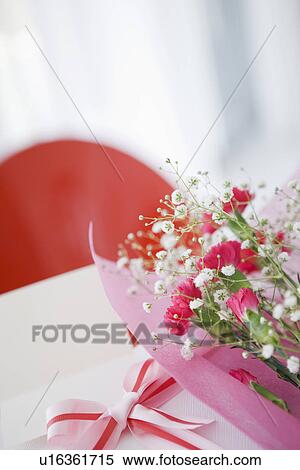 Bouquet of carnations and baby's breath with a present View Large Photo Image Stock Photography - Bouquet of carnations and baby's breath with a present. Fotosearch