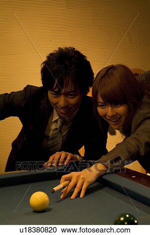 Stock Image - Business colleagues playing pool. Fotosearch