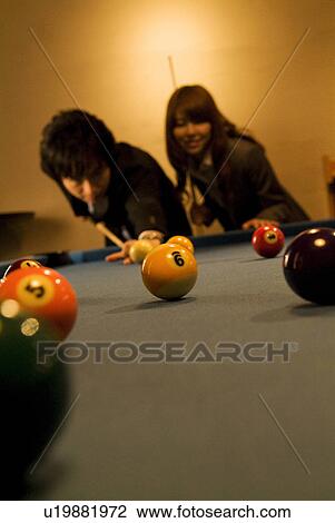 Stock Image - Business colleagues playing pool. Fotosearch