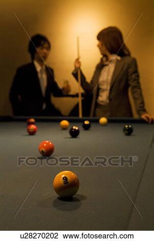 Stock Image - Business colleagues playing pool. Fotosearch